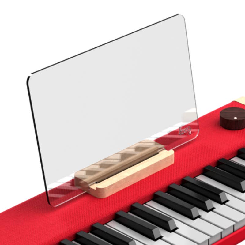 The Complete Set: Loog Piano + features a clear acrylic music stand with rounded corners on a wooden base, positioned above the keys of the red portable digital piano for both style and function.