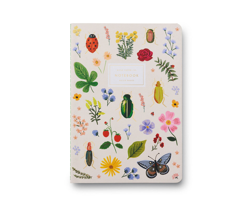 The Assorted Set of 3 Curio Notebooks features white covers with vibrant botanical and insect illustrations, a central "NOTEBOOK" label, and ruled pages—ideal for anyone who appreciates artistic notebooks.