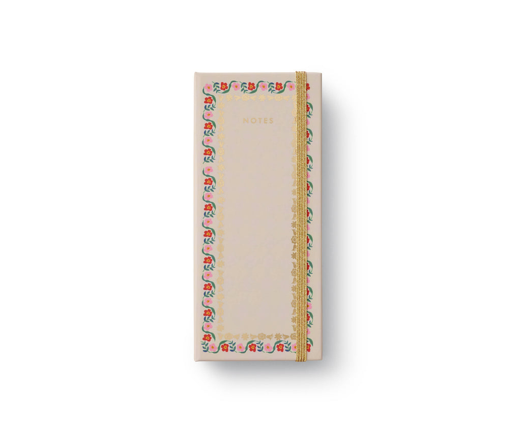 The Delphine Sticky Note Folio is a rectangular tear-off pad with a light cover, gold "NOTES" text, gold elastic band, and a colorful border inspired by the Delphine pattern with small red, green, and blue floral accents.