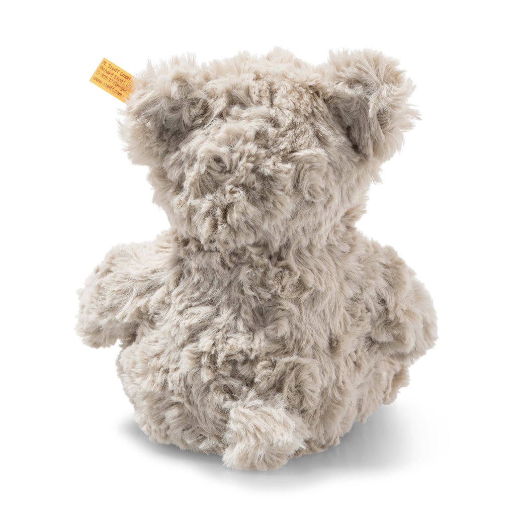 The Steiff Honey Teddy Bear Stuffed Plush, 8 inches, is shown from behind with soft light-gray fur, round ears, and a signature yellow tag on its left ear, sitting against a plain white background.