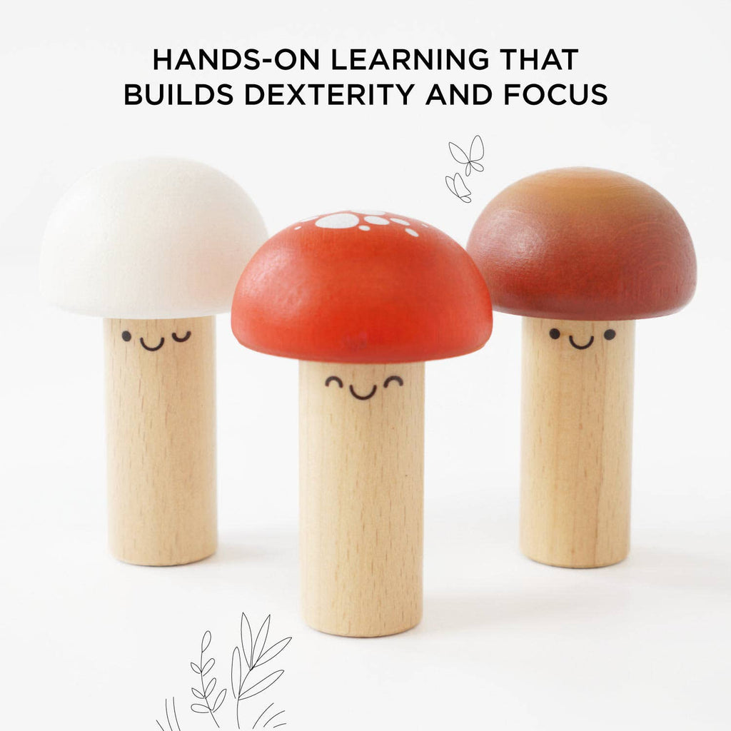 Three smiling wooden mushrooms with colorful caps stand together. Text above reads, "Woodland Mushroom Hammer Game: Hands-on learning that builds fine motor skills, dexterity, and focus.