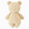 The Cuddle + Kind Baby Bouclé Bear - Honey is shown from the back, featuring soft beige Peruvian alpaca yarn, round ears, and no visible facial features against a plain white background.