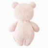 The Cuddle + Kind Baby Bouclé Bear - Strawberry is a soft, fluffy, light pink teddy bear made from Peruvian alpaca yarn. Shown from the back on a white background, it features round ears, short arms and legs, and no visible facial features.