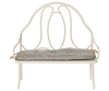 The Maileg Vintage Bench, Miniature - Off White features a decorative rounded backrest and a light gray floral cushion, creating a cozy, perfectly sized seat for bunny and rabbit friends.