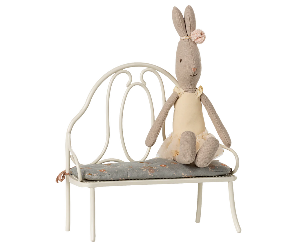 The Maileg Vintage Bench, Miniature - Off White features a blue floral cushion and is perfectly sized for any bunny or rabbit.