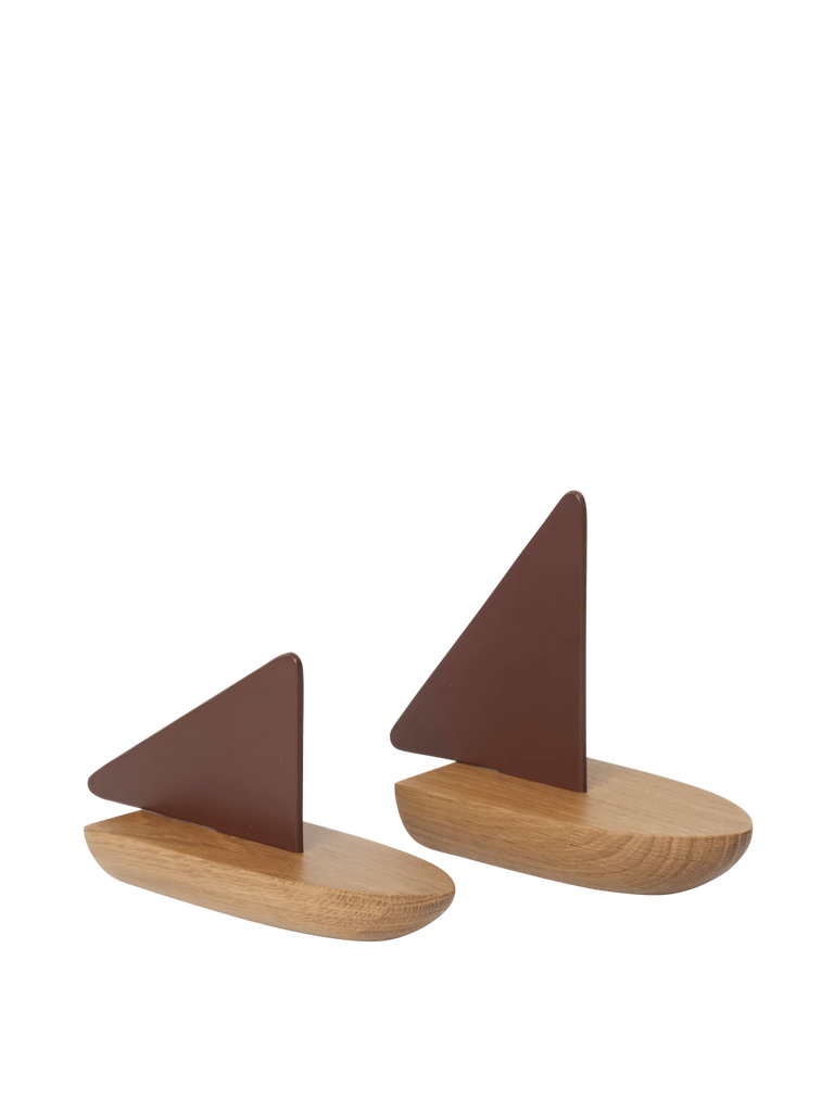 The Ferm Living Opty Boat - Set of 2 features modern bookends with FSC-certified oak oval bases and triangular brown metal supports, placed side by side on a plain background.