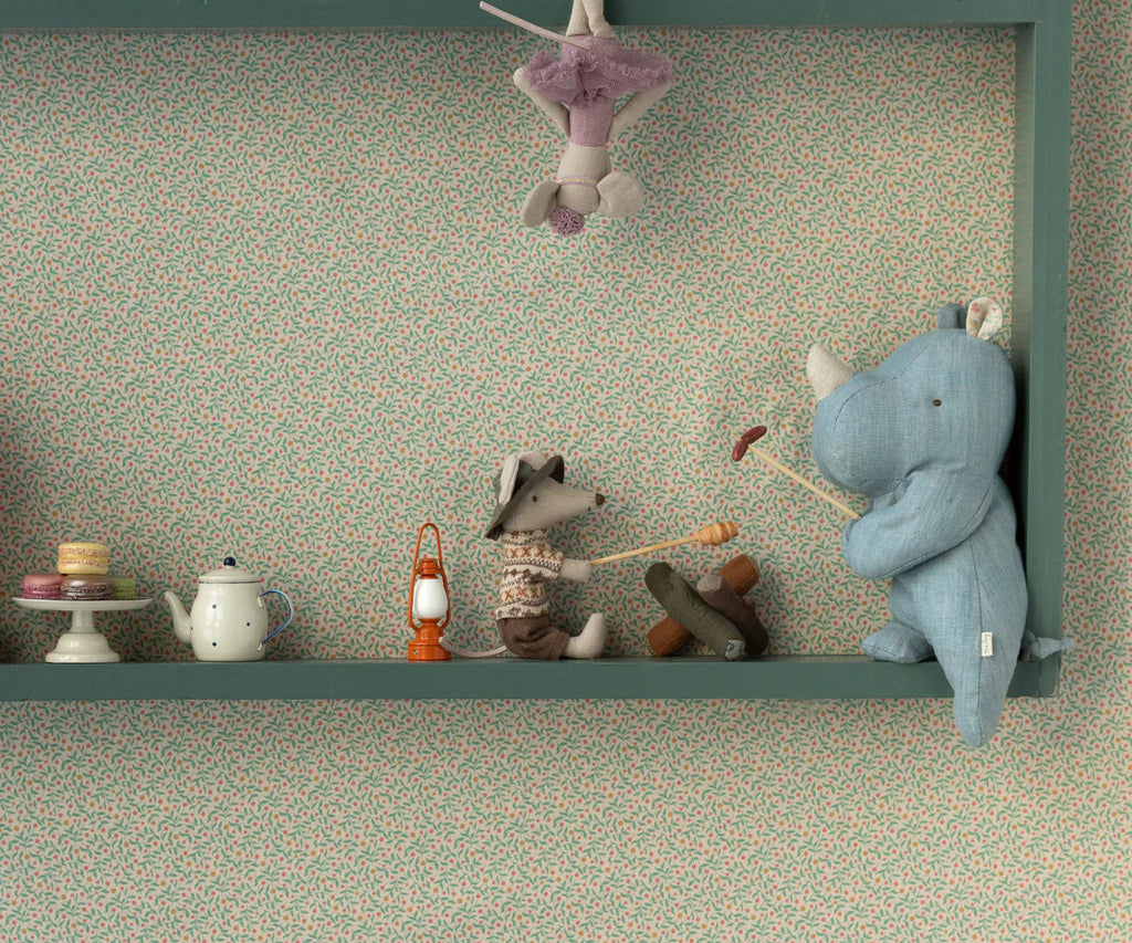 A shelf displays a toy tea set, macarons, a plush fox roasting a marshmallow, and the Maileg Small Rhino - Blue Sand. A ballerina mouse hangs above against floral wallpaper—perfect Safari friends.