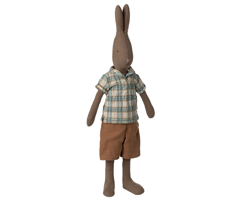 The Maileg Rabbit, Size 3 - Brown, stands upright in a blue and brown plaid shirt with brown shorts. This plush toy features long ears, stitched facial details, and a soft fabric body—perfect for cuddling or imaginative play.