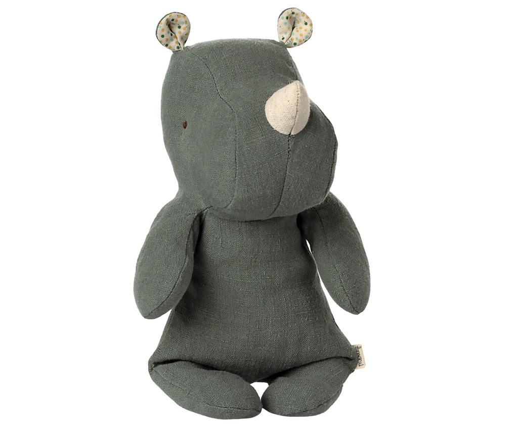 The Maileg Small Rhino - Pine is a soft, green stuffed toy made with recycled polyester. It features a white horn, polka dot ears, stitched details, and floppy limbs, sitting upright from the Safari friends collection.