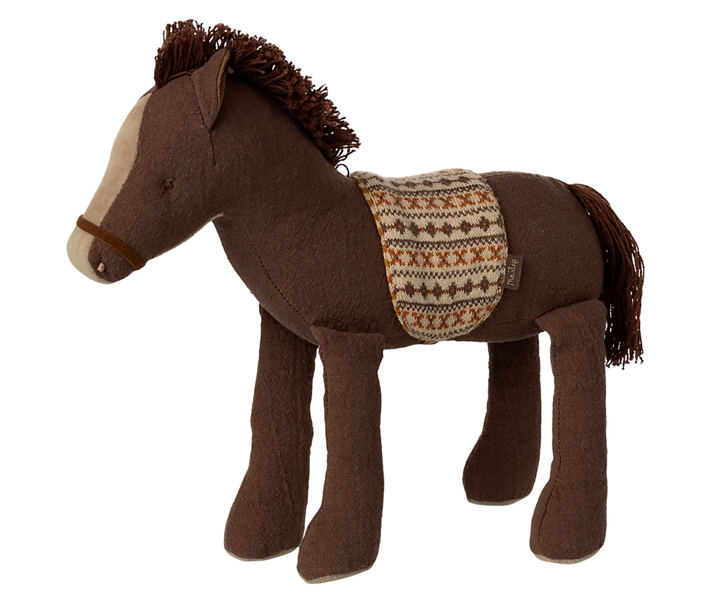 The Maileg Pony, Medium is a plush brown pony with a cream face, yarn mane and tail, and a patterned saddle blanket in brown, cream, and orange—crafted from soft fabric for cozy play.