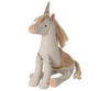 The Maileg Unicorn, Medium is a plush toy made from linen-cotton with cream fabric, a gold horn, pink nose, and a decorative saddle, sitting upright against a striped pastel background.