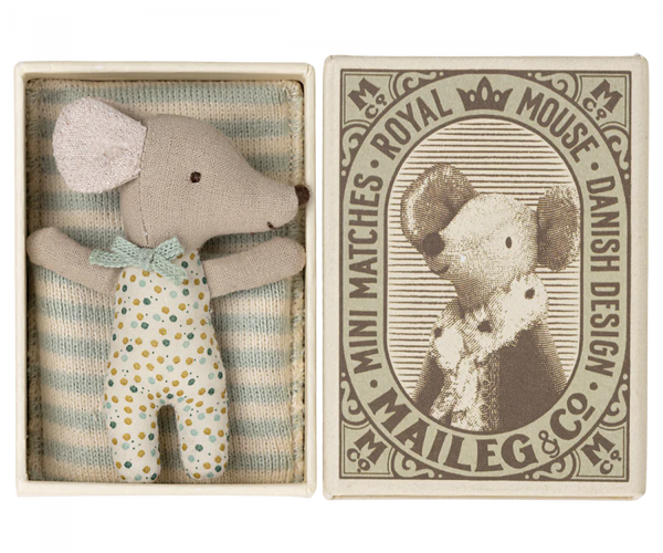 a small mouse doll inside a match box, sleeping with a blanket.