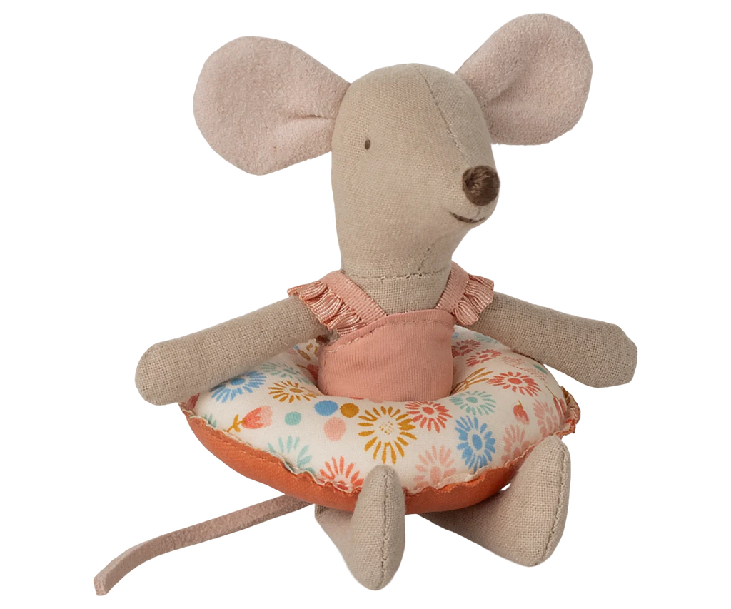 The Maileg Beach Mouse With Float, Little Sister - Flower features a soft beige mouse with large ears and a long tail, wearing a pink swimsuit and sitting inside a colorful floral-patterned float.