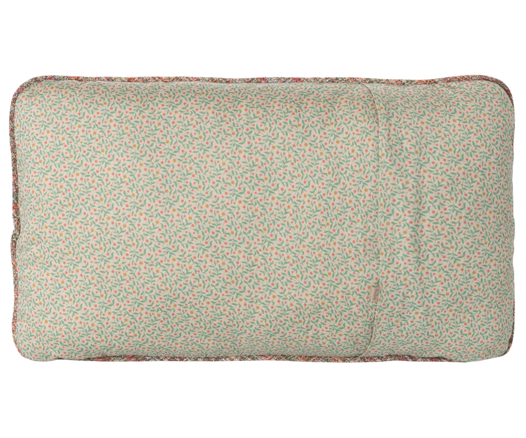 The Maileg Cushion - Unicorn is a rectangular cotton pillow with a light cover, decorated with a small, scattered green and red leaf print. Photographed from above on a plain background.