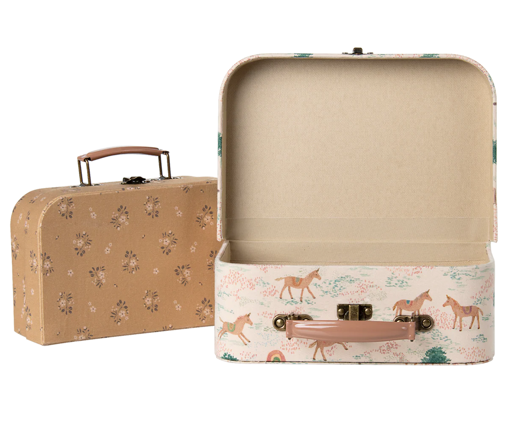 The Maileg Suitcase Set, 2-Pieces - Unicorn includes two small vintage-style cases—one closed with a floral design, the other open featuring a unicorn and tree print outside and a plain interior—ideal for charming toy storage.