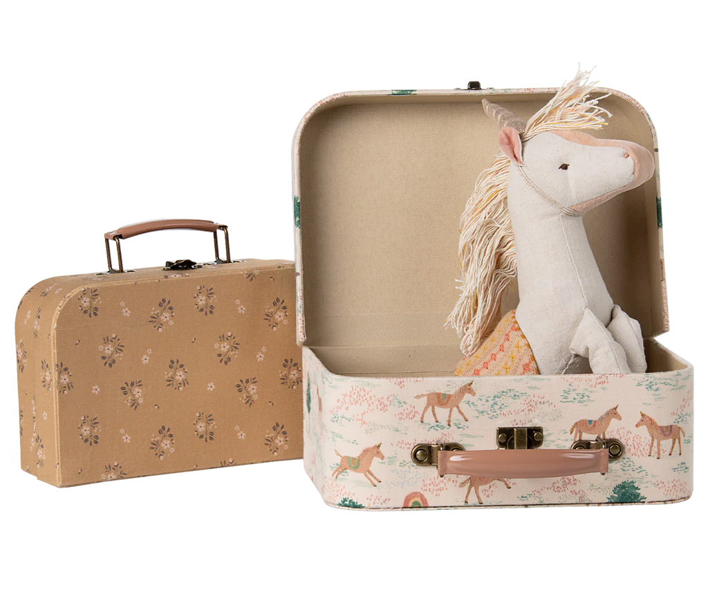 The Maileg Suitcase Set, 2-Pieces - Unicorn includes two vintage-style cases—one floral, one unicorn-themed. The unicorn suitcase opens to reveal a plush unicorn toy, ideal for adorable toy storage or display.
