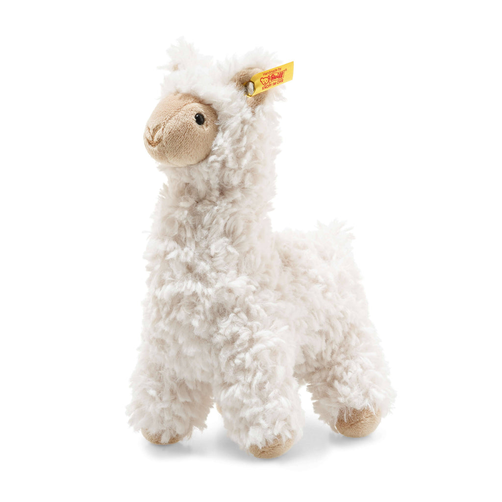 The Steiff Leandro Llama Plush Toy, 7 Inches, is a fluffy white plush with a light brown face, feet, and inner ears, featuring a yellow tag on its left ear. It stands upright on all four legs and is great for any soft cuddly friends collection.