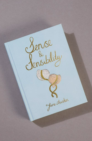 The Sense and Sensibility | Collector's Edition | Hardcover Book by Jane Austen has a light blue cover with gold script and three intertwined balloon illustrations, shown in a photo on a gray background.