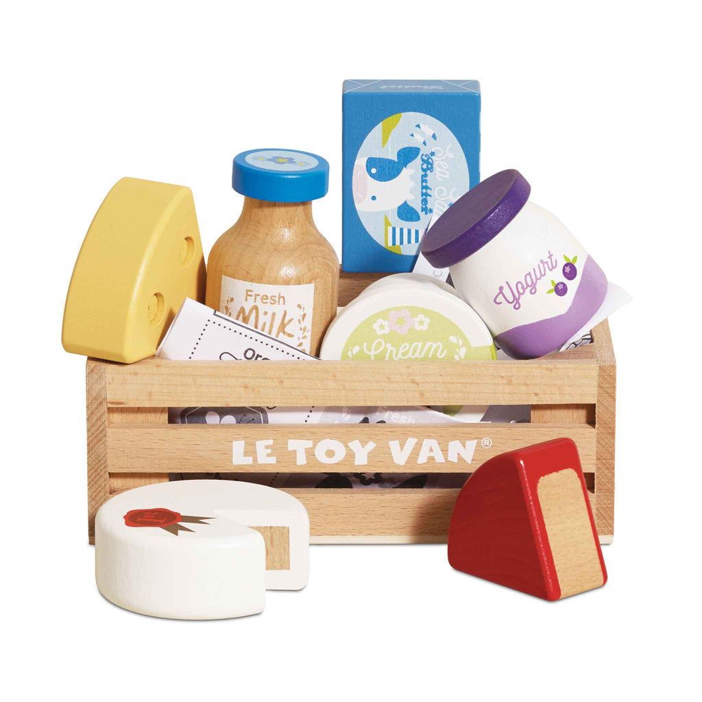 The Cheese & Dairy Wooden Market Crate by LE TOY VAN includes a wooden crate filled with colorful pretend milk, cheese, yogurt, cream, butter, and cake—an ideal educational toy for kids.