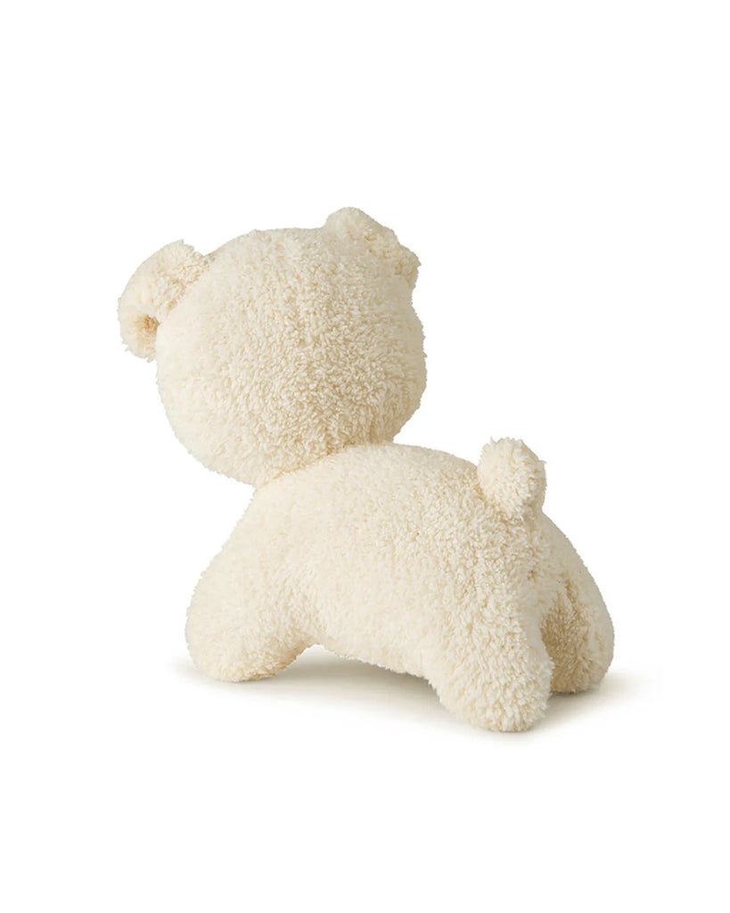 The Miffy Snuffy Stuffed Animal from Bon Ton Toys is cream-colored, shown from behind sitting on all fours with its head turned left. It features a soft, fuzzy texture and eco-friendly recycled PET filling.