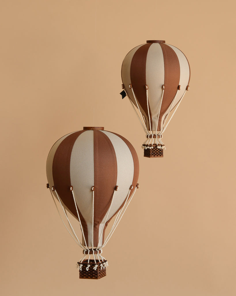 The Hot Air Balloon - Dark Brown features brown and beige stripes with a small woven basket, hanging against a solid beige background—perfect as handmade children's room decoration or charming hot air balloon-themed decor.