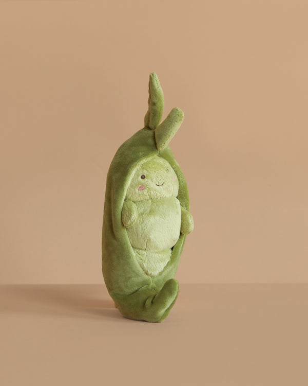 The Pia Pod Plush Toy is a soft, pea pod-shaped stuffed toy with a cute round face and small arms. It stands upright against a plain beige background—an adorable gift for kids.