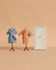 Two miniature dress forms display tiny vintage outfits from the Maileg Mum Mouse Wardrobe Set, standing next to a small white mouse closet against a beige background.