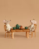 Two Maileg Royal Twin Mice in crowns and capes sit at the Maileg Royal Dining Set—a golden table with a green teapot, cups, and cake—creating a charming Christmas tea party scene against a plain beige background.