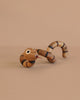 Spring Copenhagen The Snake, featuring black stripes, movable segments, googly eyes, and a red tongue, is posed on a plain beige background—making it a charming piece of wooden décor inspired by the Chinese zodiac snake.