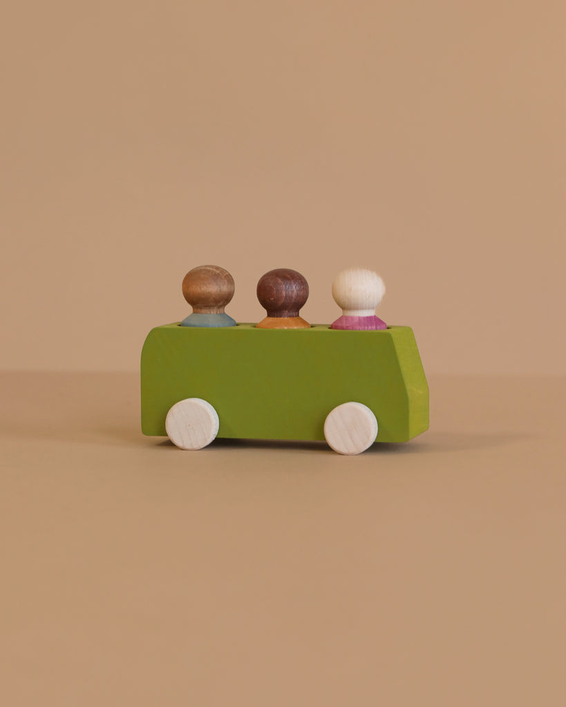 The Lubulona Wooden Bus with 3 Figures - Lime features a green bus and three wooden figures in brown, dark brown, and white, shown on a beige surface with a minimalist design perfect for eco-friendly children's play.