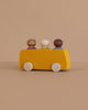 The Lubulona Wooden Bus with 3 Figures - Yellow features a minimalist yellow wooden bus and three colorful peg figures, displayed on a neutral beige background.