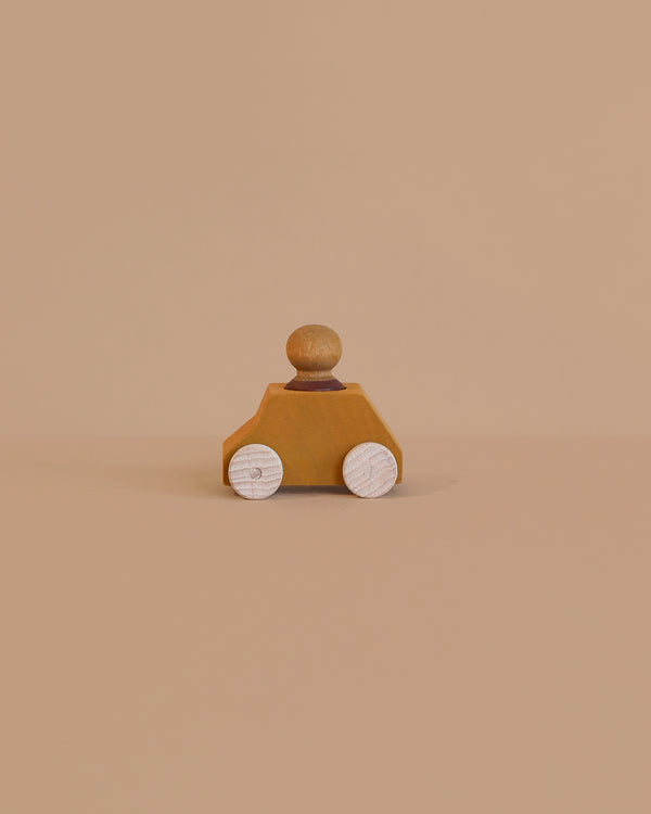 The Lubulona Wooden Car with Figure - Ochre is a small eco-friendly toy featuring white wheels and a round peg figure on top, displayed on a plain beige background.