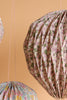 Close-up of Meri Meri x Liberty Origami Balloon Decorations featuring paper lanterns with Liberty pastel floral prints, hanging by pink and white strings against a peach background—ideal for baby showers.