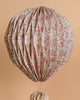 The Meri Meri x Liberty Origami Balloon Decorations feature a vibrant Liberty floral print in pink, green, and brown—ideal for adding charm to any nursery against a peach-hued backdrop.