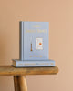 A light blue Collector's Edition hardcover of "The Return of Sherlock Holmes" stands upright on a wooden surface, with another copy flat beneath it, set against a beige background.
