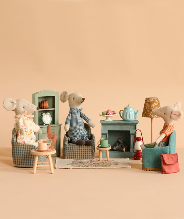 Maileg Afternoon Tea With Grandma And Grandpa features three plush Maileg Mice in a cozy miniature living room with armchairs, a table, fireplace, tea set, and lamp—perfect for a warm and inviting tea party scene.