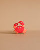 A small, red and orange cartoon crab with two raised claws and wide eyes stands on a light brown surface—just like the handcrafted Holztiger Crab, made in Europe and ships in one week.