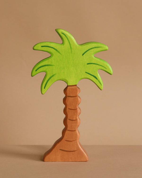The Holztiger Palm Tree is a handcrafted wooden figure featuring a brown trunk and bright green leaves, shown standing upright against a plain beige background.