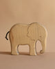 The Handmade Wooden Elephant is a sustainable hardwood toy featuring simple carved details and a small black tail, displayed on a plain beige background.