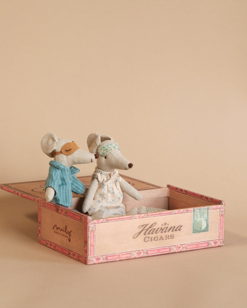The Maileg Living Room Set features two mice in vintage-style outfits sitting together inside an open cigar box, placed against a simple beige background.
