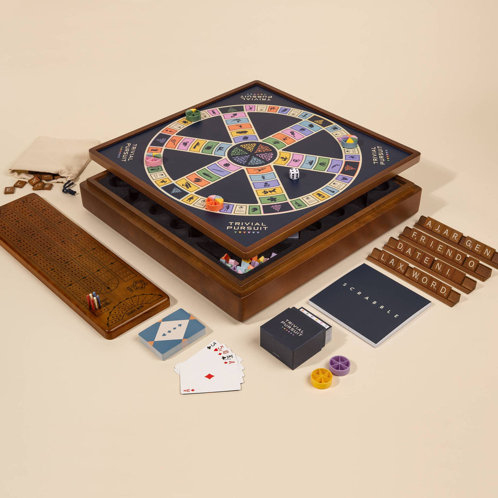 The 3-in-1 Game Collection features Scrabble tiles, Trivial Pursuit cards, classic playing pieces, and a wooden cribbage board with pegs—everything neatly arranged for hours of fun.
