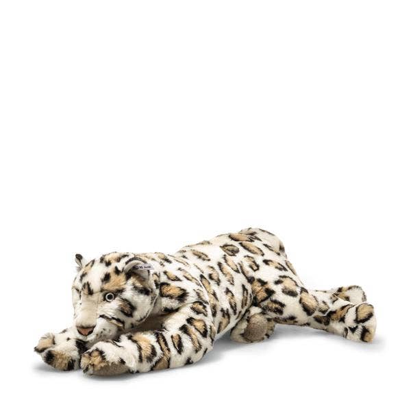 The Steiff XL Parddy Snow Leopard 21" is a realistic plush toy with black spots and blue eyes, lying on its stomach with front paws stretched forward against a white background.
