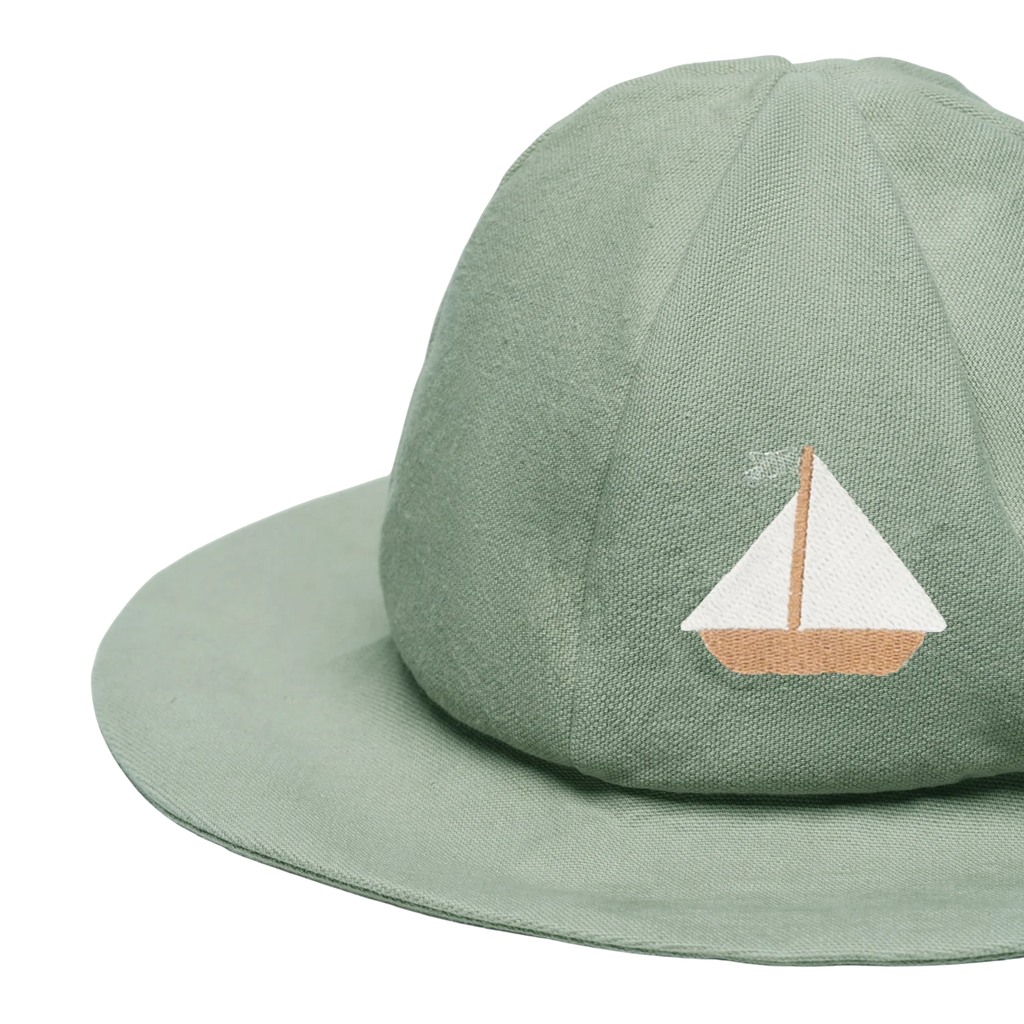 The Donsje Organic Cotton Steijn Boat Hat is light green with a wide brim and features an embroidered sailboat with a white sail and tan hull on the front, offering stylish sun protection.