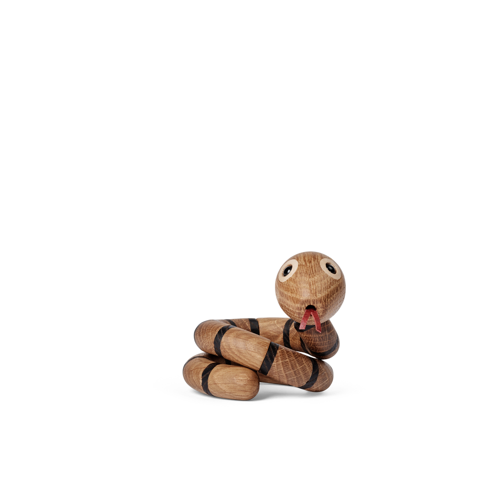 The Spring Copenhagen The Snake is a wooden toy snake with painted black stripes, big round eyes, and a red tongue, coiled up as a charming piece of décor against a white background.