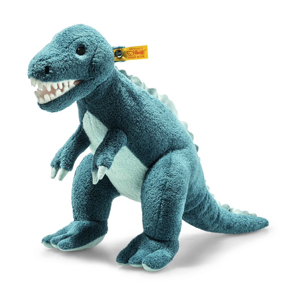 The Steiff Thaisen Tyrannosaurus "T-Rex" Dinosaur Plush Toy, 14 Inches, is blue and white with a friendly face, felt claws, soft back spikes, and features a yellow Steiff ear tag.