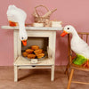Two Duck Lamps, ideal for children's room decor, explore a small vintage oven—one on a chair, the other peering at muffins inside. Baking tools and baskets sit atop the oven, all set against a charming pink wall.