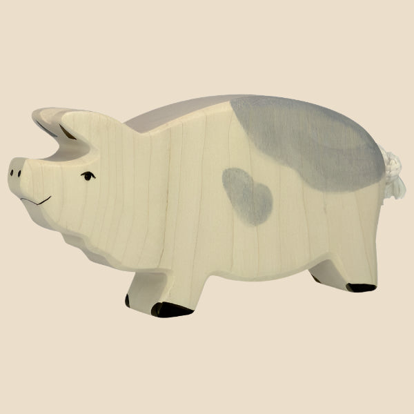 The Holtztiger Boar, handcrafted from maple and beech wood with a light cream body, gray markings, heart-shaped spot, black hooves, and a simple face—classic HOLZTIGER—ships in one week. Shown against a beige background.