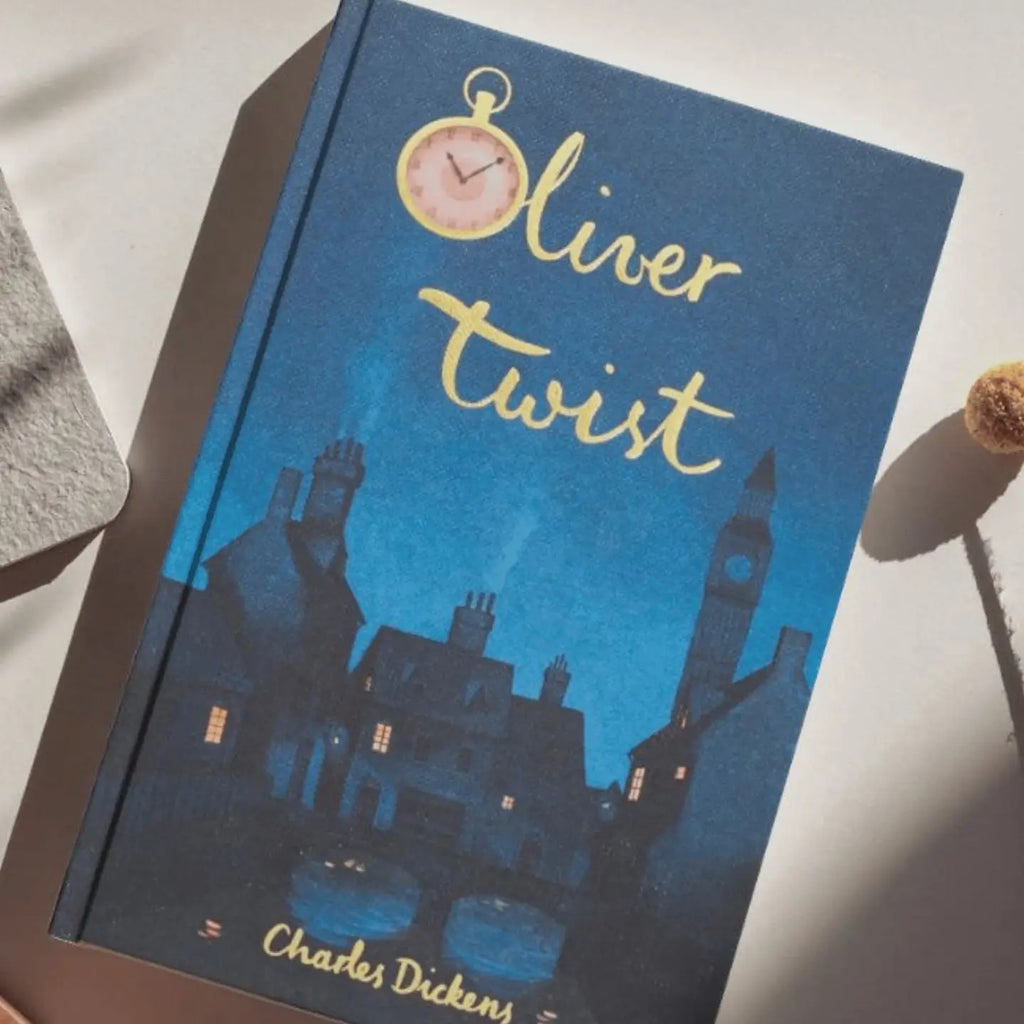 The blue hardcover "Oliver Twist | Dickens | Collector's Edition" features an illustrated nighttime cityscape with chimneys, a clock tower, and a pink pocket watch above the title.