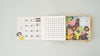 An open Magnetic Number Play Set displays a calendar with numbers and symbols on the left and colorful magnetic wooden pieces shaped like animals, objects, and alphabet cards on the right.