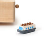 The Paris Music Box, featuring blue windows and brown seats, is ideal for decoration and sits on a white surface near the corner of a light wooden object.